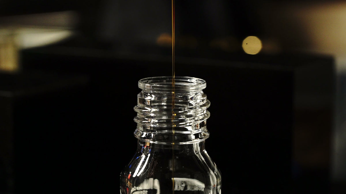 Firdaus oud oil being poured into a bottle